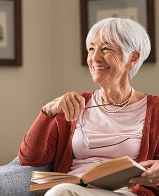 Senior woman sitting in chair reading a book