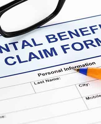 Closeup of dental insurance form with a pen and black glasses