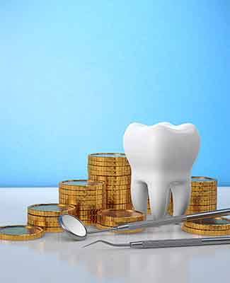 A large fake tooth next to a pile of coins and dental instruments on a reflective white surface with blue background